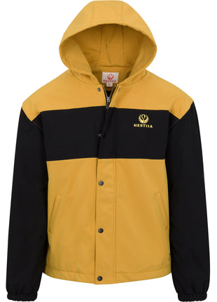 Front view of Hestiia 7K3 heated jacket. Jacket is amber, with a large black stripe across the top portion of the chest, and the Hestiia icon embroidered in a light yellow color inside the black stripe on the wearer's left side, top of chest area. Sleeves are black. Elastic bungee sleeve cuffs. Two pockets on either side of front. Snapped up storm flap with zipper visible behind it. Hood is up.