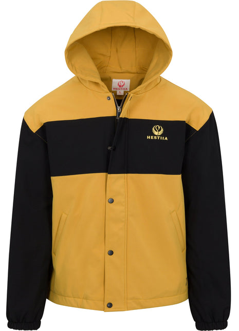 Front view of Hestiia 7K3 heated jacket. Jacket is amber, with a large black stripe across the top portion of the chest, and the Hestiia icon embroidered in a light yellow color inside the black stripe on the wearer's left side, top of chest area. Sleeves are black. Elastic bungee sleeve cuffs. Two pockets on either side of front. Snapped up storm flap with zipper visible behind it. Hood is up.